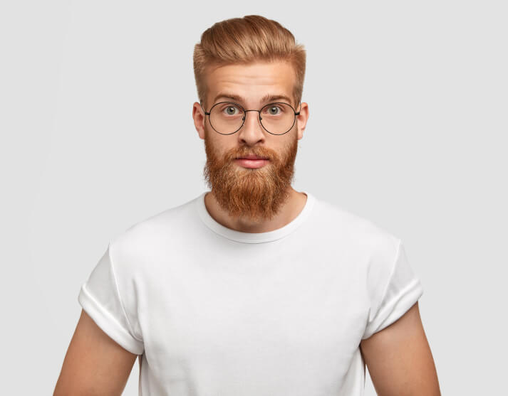 confident-ginger-man-with-trendy-hairstyle-wears-spectacles-looks-directly 1-1